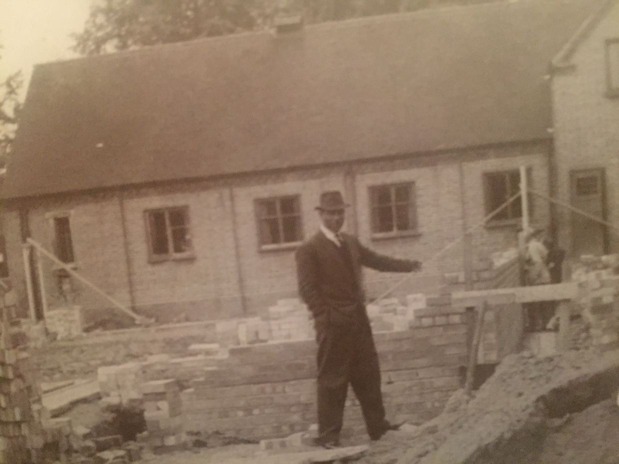 Bishop Dunn standing on a building site beside the church as it is extended