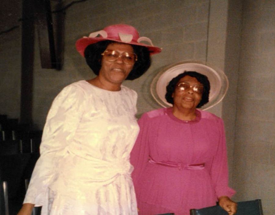 Two women in hats, one in white and one in pink